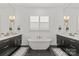 Symmetrical bathroom featuring a freestanding tub between dual vanities with marble floors at 6013 Camile Ct, Charlotte, NC 28226