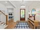 View of the bright foyer featuring hardwood floors, statement lighting, console table, and entry to mudroom at 6013 Camile Ct, Charlotte, NC 28226