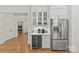 Bright butler's pantry with beverage center, refrigerator, and display cabinets at 6013 Camile Ct, Charlotte, NC 28226