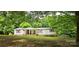 Cozy one-story home showcasing a covered porch, red shutters, and a lush green yard with mature trees at 6140 Barclay Ln, Clover, SC 29710