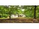 Inviting one-story home with a covered porch, red shutters, and a yard with mature trees at 6140 Barclay Ln, Clover, SC 29710