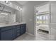 A spacious full bathroom with double sinks, drawers, and a door leading to a view of the main bedroom at 6531 Wildbrook Dr, Charlotte, NC 28269