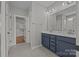 A full bathroom with double sinks, drawers, and a door leading to a walk-in closet at 6531 Wildbrook Dr, Charlotte, NC 28269