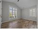 A bedroom with hardwood floors, a ceiling fan, and many windows for natural light at 6531 Wildbrook Dr, Charlotte, NC 28269