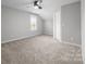 Neutral bedroom featuring a ceiling fan, window, carpet floors, and a closet door at 6531 Wildbrook Dr, Charlotte, NC 28269
