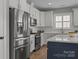 Modern kitchen features stainless steel refrigerator, white cabinets, and a central island at 6531 Wildbrook Dr, Charlotte, NC 28269