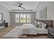 This spacious main bedroom features hardwood floors, a ceiling fan, and many windows for natural light at 6531 Wildbrook Dr, Charlotte, NC 28269