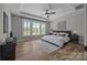 This spacious main bedroom features hardwood floors, a ceiling fan, and many windows for natural light at 6531 Wildbrook Dr, Charlotte, NC 28269