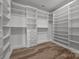 A walk-in closet with shelves, hanging rods, and hardwood floors at 6531 Wildbrook Dr, Charlotte, NC 28269
