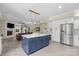 This stylish kitchen features a blue center island, stainless refrigerator, and is open to the Gathering room at 7017 S Providence Rd, Waxhaw, NC 28173