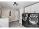 This laundry room features white cabinets and black front loading machines at 7017 S Providence Rd, Waxhaw, NC 28173