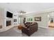 Cozy living room features a stone fireplace, leather sofa, ceiling fan, and neutral paint at 7017 S Providence Rd, Waxhaw, NC 28173
