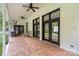 Covered patio featuring brick flooring, dark-framed doors, and relaxing outdoor seating at 7017 S Providence Rd, Waxhaw, NC 28173