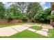 Spacious backyard with a beautiful patio surrounded by a brick wall and lush greenery at 7031 Walton Heath Ln, Charlotte, NC 28277