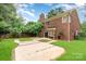 A home's backyard featuring a brick-edged patio that is surrounded by verdant grass at 7031 Walton Heath Ln, Charlotte, NC 28277