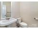 Powder room features a pedestal sink and tile flooring at 7031 Walton Heath Ln, Charlotte, NC 28277