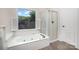 Serene bathroom showcasing a luxurious soaking tub, separate glass shower, and natural light, a relaxing retreat at 7031 Walton Heath Ln, Charlotte, NC 28277