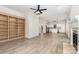 Spacious living room featuring light hardwood floors, built-in shelving, fireplace, and open kitchen views at 7031 Walton Heath Ln, Charlotte, NC 28277