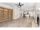 Spacious living room featuring light hardwood floors, built-in shelving, fireplace, and open kitchen views at 7031 Walton Heath Ln, Charlotte, NC 28277