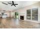 Open-concept living room with a fireplace, views into kitchen and light hardwood floors at 7031 Walton Heath Ln, Charlotte, NC 28277