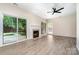 Bright living room with fireplace, sliding doors to outside, and light hardwood floors at 7031 Walton Heath Ln, Charlotte, NC 28277