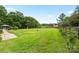 Lush backyard view featuring a well-manicured lawn, wooden fence, and a charming red barn in the distance at 867 Bellegray Rd, Clover, SC 29710