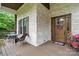 Inviting front porch with brick columns, a seating area, and a charming wooden front door at 867 Bellegray Rd, Clover, SC 29710