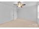 Bright bedroom with neutral walls, ceiling fan, carpet floors, and a closet at 10027 Juniper Trace Dr, Charlotte, NC 28277