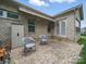 Back patio showcasing the brick exterior, complemented by modern patio furniture and serene backyard views at 1004 Fairbanks Ct, Indian Trail, NC 28079
