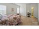Bright bedroom featuring neutral carpeting, windows with shutters, and an ensuite bathroom with stylish finishes at 1004 Fairbanks Ct, Indian Trail, NC 28079