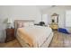 Comfortable bedroom featuring a bed, nightstand, and decorative mirror with luxury hardwood floors at 1004 Fairbanks Ct, Indian Trail, NC 28079
