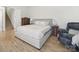 Neutral bedroom with a large bed, side tables, and a cozy chair with luxury hardwood floors at 1004 Fairbanks Ct, Indian Trail, NC 28079