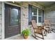 Inviting front porch with rocking chairs, a charming door, and brick accents at 1004 Fairbanks Ct, Indian Trail, NC 28079