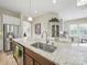 Kitchen island features granite countertops, stainless steel sink, and is surrounded by white cabinetry at 1004 Fairbanks Ct, Indian Trail, NC 28079