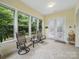 Bright sunroom featuring tile floors, large windows with backyard views, and double doors at 1004 Fairbanks Ct, Indian Trail, NC 28079