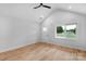Bright living room features wood flooring, a modern ceiling fan, and a large window overlooking the front yard at 101 Churchill Dr, Kings Mountain, NC 28086