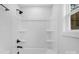 A clean white bathroom features a shower and tub with modern black fixtures and a window for natural light at 103 Churchill Dr, Kings Mountain, NC 28086