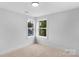 Bright bedroom featuring neutral carpet and walls, well-lit by two windows overlooking green space at 103 Churchill Dr, Kings Mountain, NC 28086