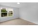 Bright bedroom featuring neutral carpet and walls, well-lit by a window overlooking green space at 103 Churchill Dr, Kings Mountain, NC 28086
