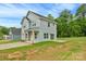 Two-story home with light blue siding, front porch with natural wood supports, and spacious yard at 103 Churchill Dr, Kings Mountain, NC 28086