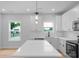 Modern white kitchen with stainless steel appliances, subway tile backsplash, and sleek pendant lighting at 103 Churchill Dr, Kings Mountain, NC 28086