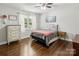 Bright bedroom featuring hardwood floors, a ceiling fan, neutral walls, and natural light from the window at 106 Phifer St, Fort Mill, SC 29715