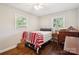 Inviting bedroom featuring hardwood floors, two windows, and a light color palette; complete with dresser and lamp at 106 Phifer St, Fort Mill, SC 29715