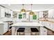 Bright kitchen featuring an island with seating, stylish lighting, white cabinets, and modern stainless steel appliances at 106 Phifer St, Fort Mill, SC 29715