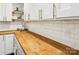 Kitchen counter with butcher block, white cabinets, and elegant subway tile backsplash at 106 Phifer St, Fort Mill, SC 29715