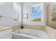 Bathroom featuring a soaking tub, tiled surround, and natural light from a large window, next to shower at 1070 Blueberry Rd, Salisbury, NC 28147