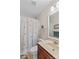 This secondary bathroom has a butterfly shower curtain, wood vanity, and white sink, creating a cheerful space at 1070 Blueberry Rd, Salisbury, NC 28147