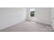 A bright bedroom with neutral carpeting and a window allowing for natural light at 11131 Cardinal Creek Ave, Charlotte, NC 28215
