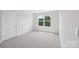 A bright bedroom with neutral carpeting and a window allowing for natural light at 11131 Cardinal Creek Ave, Charlotte, NC 28215