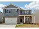 Two-story home with a brick and blue facade, attached garage, and a covered front porch at 11131 Cardinal Creek Ave, Charlotte, NC 28215